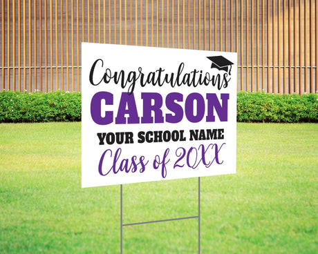 Custom graduation yard sign with bold name design in purple and black, featuring a congratulatory message, a graduation cap graphic, and customizable school name and class year. Printed on durable Coreplast plastic, available in single or double-sided options. Perfect for high school and college graduates.