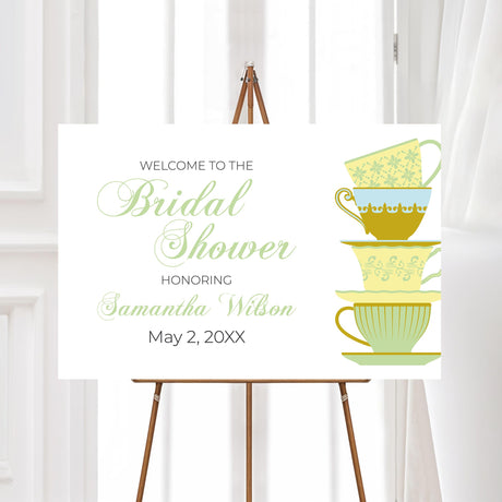 Bridal tea party welcome sign featuring a vintage teacup illustration in green and gold hues. Customizable with the bride’s name and event date, perfect for greeting guests at a tea-themed bridal shower.