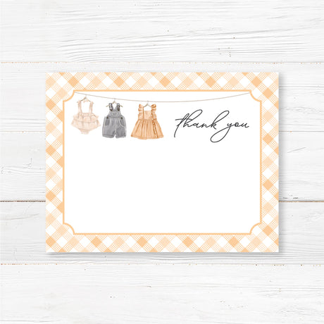 Printed baby shower thank you card featuring a charming baby clothesline and gingham border. Elegant and rustic design, perfect for sending heartfelt messages