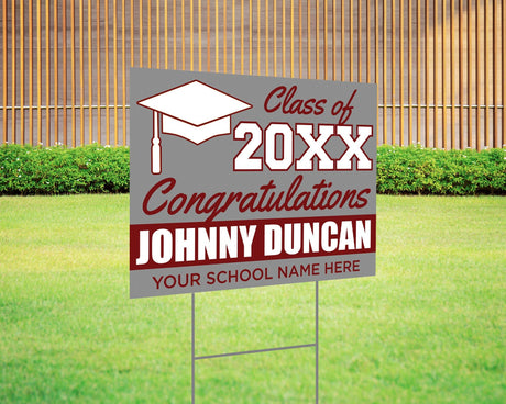 Custom graduation yard sign with bold maroon and gray color block design, featuring a graduation cap graphic, personalized graduate’s name, school, and class year. Printed on durable Coreplast plastic, available in single or double-sided print, perfect for high school and college graduates.