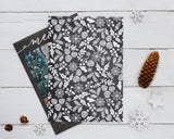 Personalized Cursive Merry Christmas photo card featuring a customizable family photograph, elegant white script greeting, and family signature on a charcoal background. The double-sided printed card includes a coordinating reverse pattern of snowflakes, pinecones, evergreen branches, holly leaves, and berries. - back.