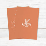 Terracotta wedding invitation with white calligraphy and ornate Celtic-style monogram - back side