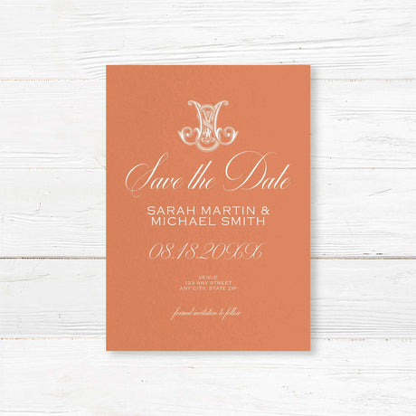 Terracotta save the date card with white script and ornate Celtic initial monogram