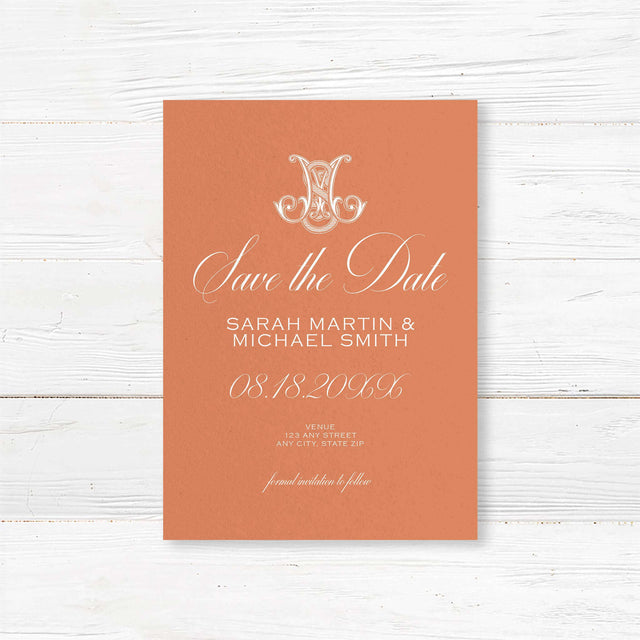 Terracotta save the date card with white script and ornate Celtic initial monogram