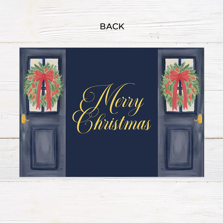Personalized Doorway to Christmas gatefold card featuring navy blue doors decorated with festive evergreen wreaths, red bows, and elegant gold Merry Christmas lettering. The doors open to reveal a family photograph with a customizable holiday greeting and family name. - back.