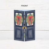 Personalized Doorway to Christmas gatefold card featuring navy blue doors decorated with festive evergreen wreaths, red bows, and elegant gold Merry Christmas lettering. The doors open to reveal a family photograph with a customizable holiday greeting and family name. - front folded.