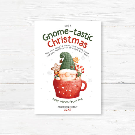 Festive Christmas greeting card featuring a gnome in a red cocoa mug with candy canes and gingerbread cookies. Cheerful watercolor holiday design.