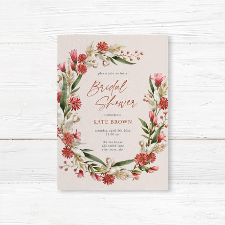 Elegant bridal shower invitation with a red, blush, and beige watercolor floral wreath, printed on premium cardstock.