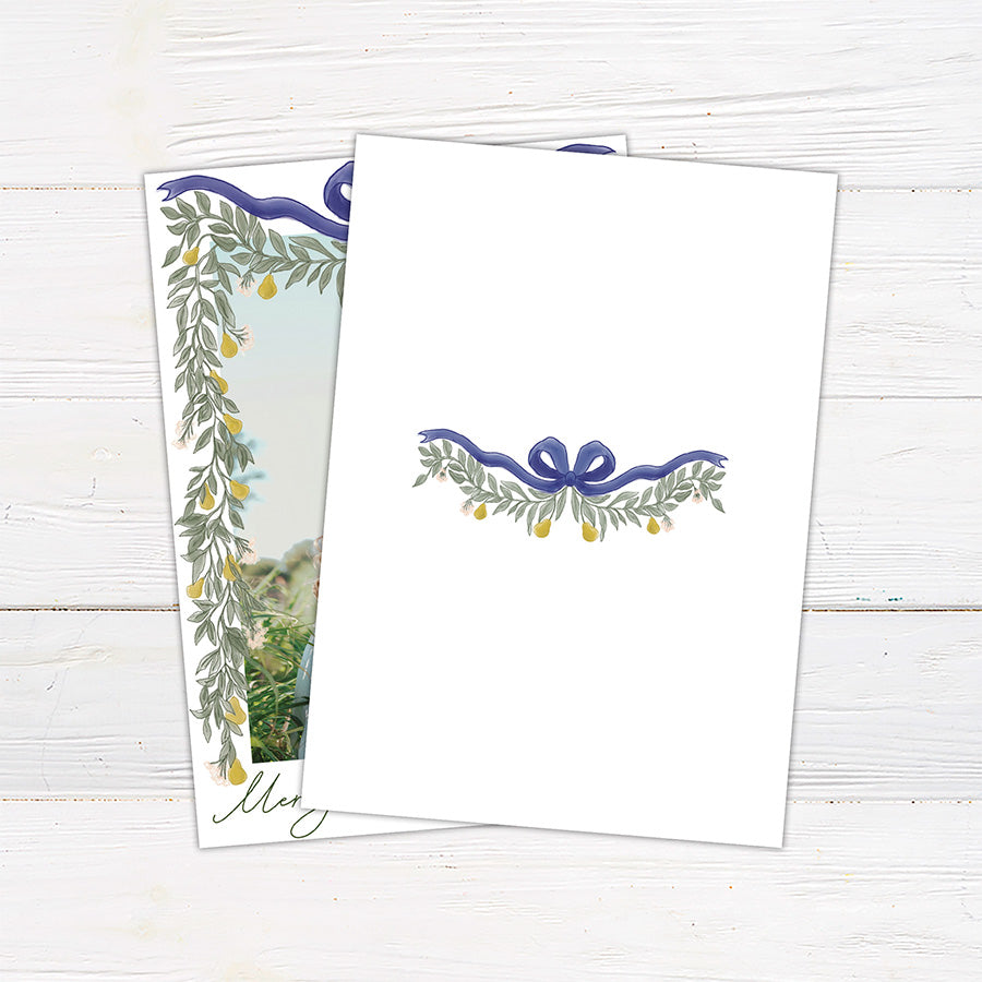 Personalized Christmas photo card featuring a family picture framed by cascading greenery, golden pears, and an elegant ribbon bow. The design includes a Merry Christmas greeting with a custom family name and year. back