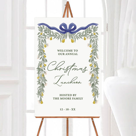 Elegant pear greenery Christmas luncheon welcome sign framed with watercolor greenery, golden pears, flowers, and a bow. The sign features elegant script with personalized host and event information.