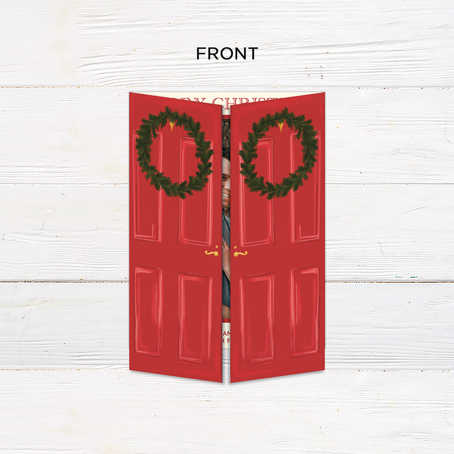 Personalized Home for the Holidays Christmas gatefold photo card featuring festive red double doors decorated with evergreen wreaths and customizable family photos. The folding holiday card opens to reveal a large photo and personalized Christmas greeting with an additional four-photo collage. Two-photo variant. - front