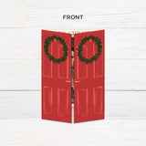 Personalized Home for the Holidays Christmas gatefold photo card featuring festive red double doors decorated with evergreen wreaths and customizable family photos. The folding holiday card opens to reveal a large photo and personalized Christmas greeting with an additional four-photo collage. Two-photo variant. - front