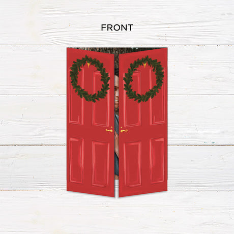 Personalized Home for the Holidays Christmas gatefold photo card featuring festive red double doors decorated with evergreen wreaths and customizable family photos. The folding holiday card opens to reveal a large photo and personalized Christmas greeting with an additional four-photo collage. Four-photo variant. - front.