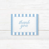 Wedding thank you card with floral monogram crest of blue hydrangeas, powder blue and white vertical stripes, and romantic serif and script fonts matching Hydrangea Crest suite.