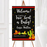 A fiesta-themed Let's Taco Bout a baby baby shower welcome sign with tacos, a sombrero, cactus, and guitar. The design uses bright colors on a dark background.