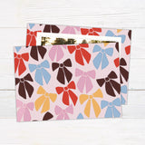 Personalized family Christmas photo card featuring a large photograph surrounded by a playful pattern of colorful ribbon bows. The coordinating back features an all-over illustrated bow pattern.