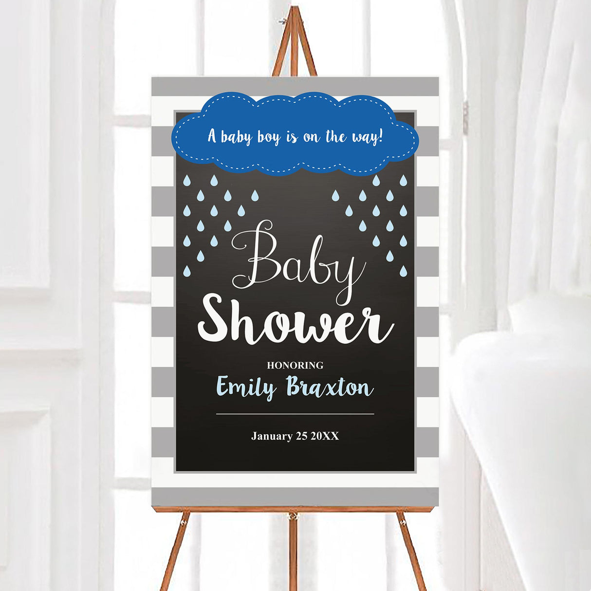 A rain baby shower welcome sign with a cloud and blue raindrops. The design uses blue and gray colors.