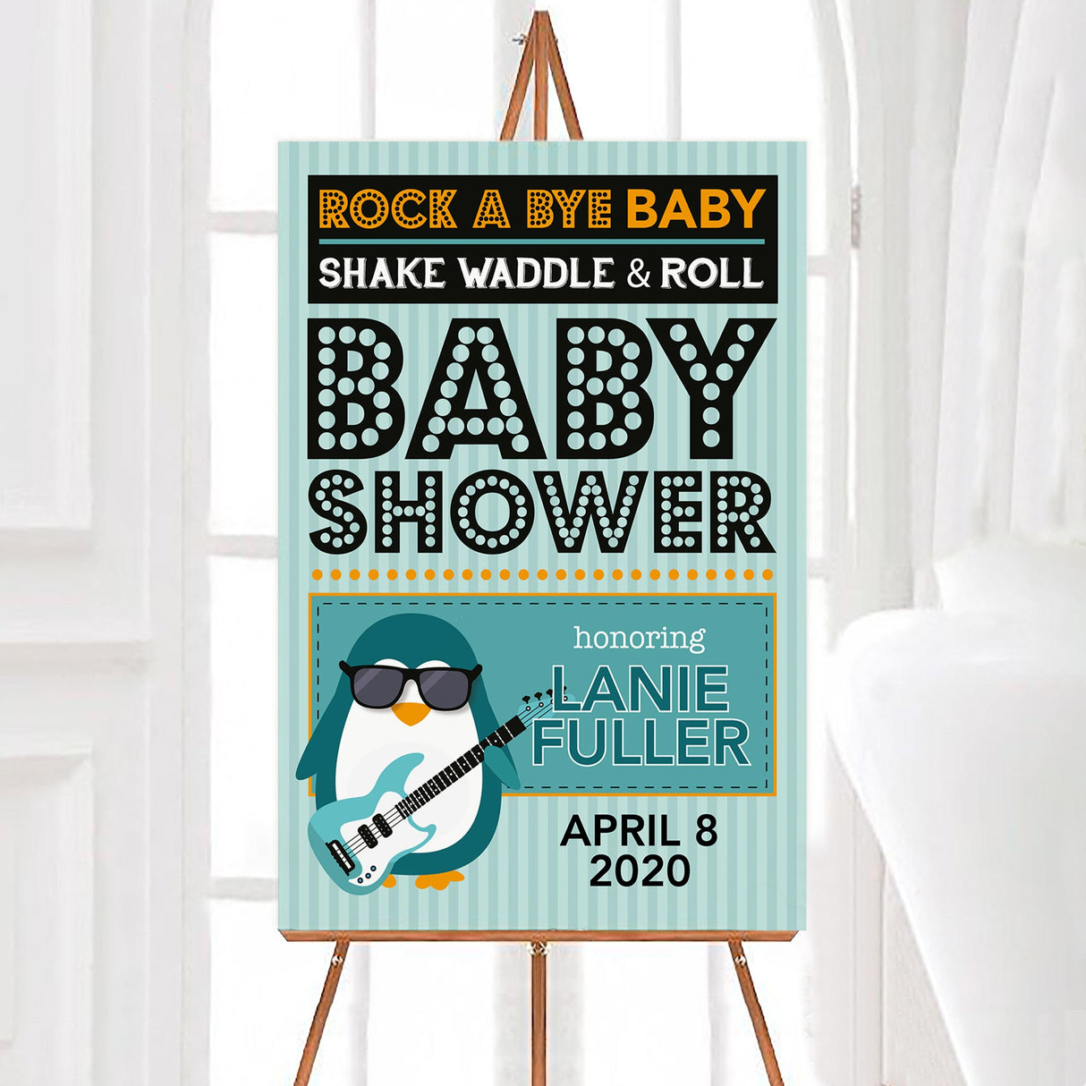 A rock a bye baby shower welcome sign with a penguin holding a guitar and bold lettering. The design uses teal, orange, and black colors with a music theme.