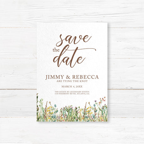 Elegant wedding save the date with a minimalist design featuring delicate script and serif fonts. The bottom of the invitation is adorned with a watercolor wildflower border, adding a rustic and romantic touch. The text includes event details such as the date, time, and venue, with a note about cocktails, dinner, and dancing to follow. The color palette consists of soft neutrals and earth tones, creating a timeless and sophisticated look.