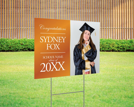 Graduation yard sign featuring a split design with a side photo and bold gold text on the left, displaying the graduate’s name, class year, and school name. Printed on durable Coreplast plastic, available in custom colors and single or double-sided print, perfect for high school and college graduation celebrations. orange white