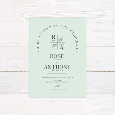 Minimalist monogram wedding invitation with botanical crest and arch layout in modern green tones
