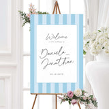 Wedding welcome sign with vertical soft blue and white stripes, clean white panel, and handwritten script and serif font combo, matching the Simply Written wedding suite.