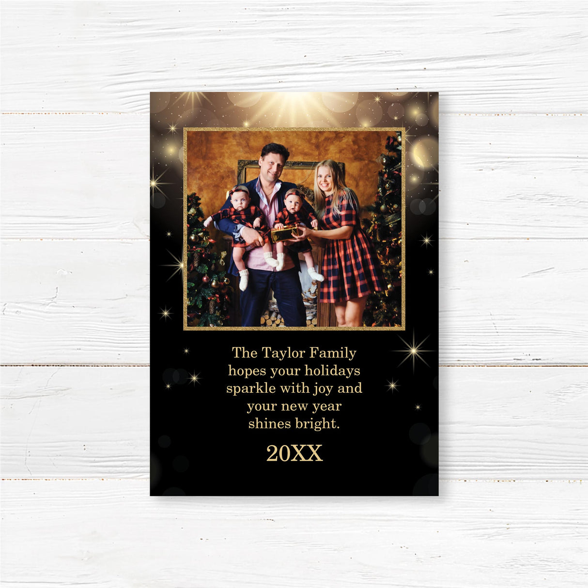 A personalized black and gold Christmas card featuring a family photo surrounded by sparkling lights and snowflakes. Includes festive holiday text and family greeting.