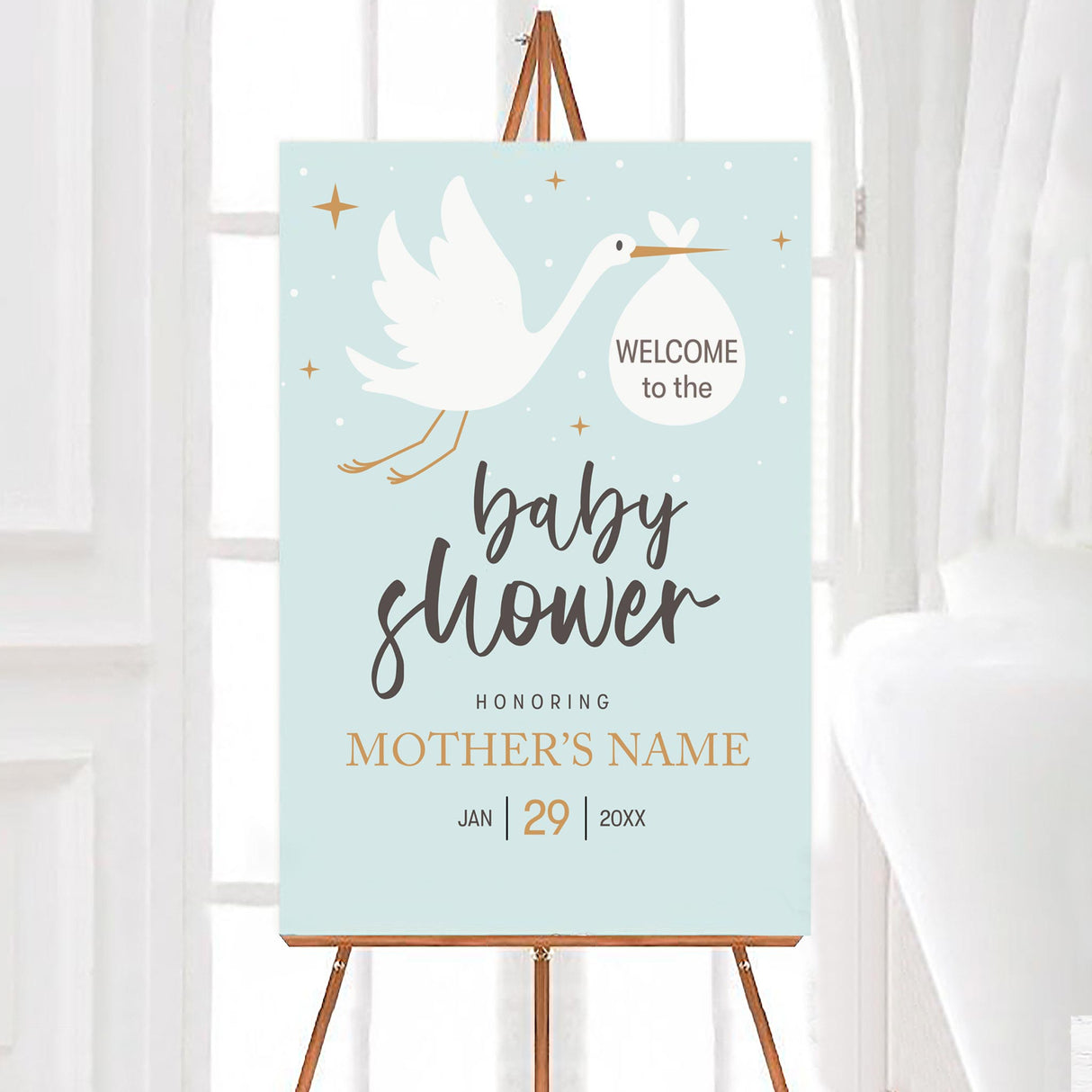 A stork baby shower welcome sign featuring a stork carrying a bundle on a blue background. The design uses simple text and soft colors.