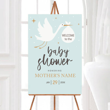 A stork baby shower welcome sign featuring a stork carrying a bundle on a blue background. The design uses simple text and soft colors.