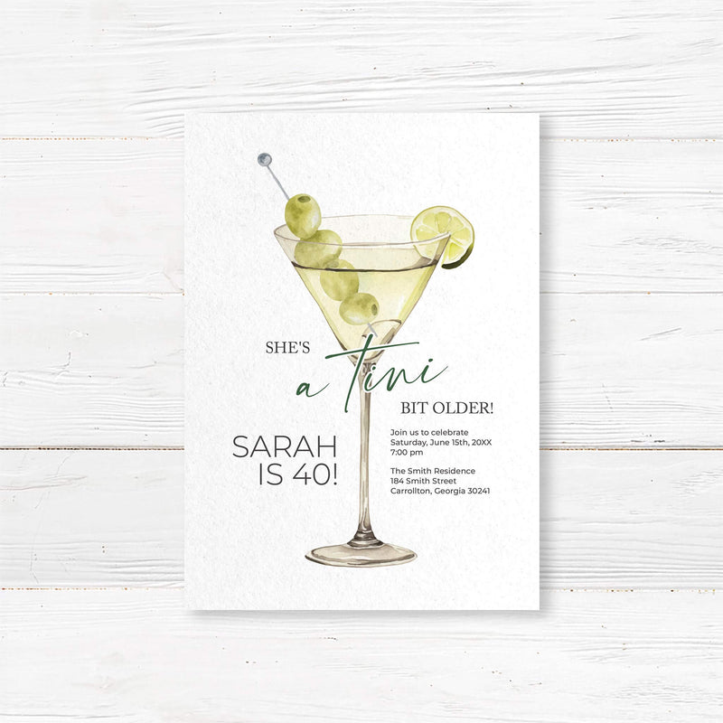 Birthday party invitation featuring a watercolor martini glass with green olives and lime, playful script and serif fonts, and text that reads “She’s a tini bit older,” ideal for cocktail-themed birthday parties.