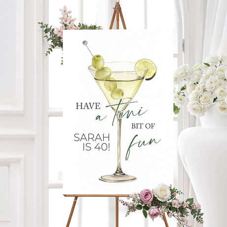 Birthday welcome sign with a watercolor martini glass, green olives, lime, and playful serif and script fonts. Coordinates with a cocktail-themed birthday celebration.