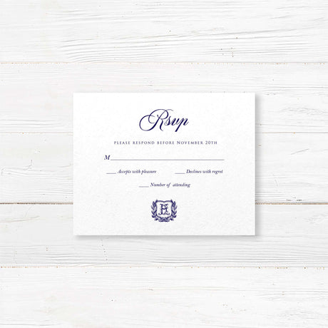 RSVP card with navy script and monogram crest design on white textured paper, for elegant traditional wedding stationery