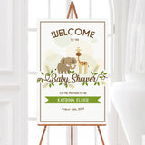 A wild animals baby shower welcome sign featuring an elephant and giraffe with greenery accents. The design uses soft neutral colors and playful animal illustrations.