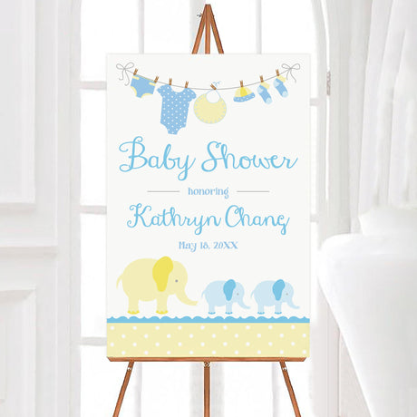 A yellow blue elephants baby shower welcome sign featuring elephants in blue and yellow. The design includes baby clothes hanging on a line and soft pastel colors.