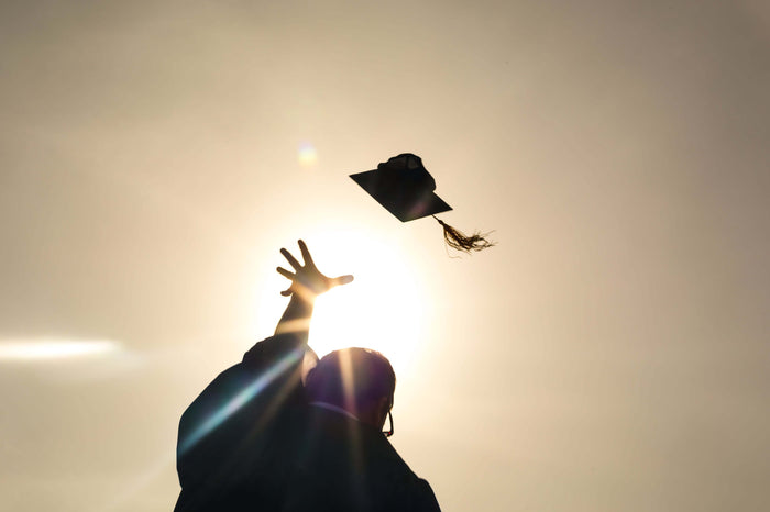 student throwing up cap