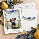 Personalized Pear & Greenery Christmas photo card featuring a family picture framed by cascading greenery, golden pears, and an elegant ribbon bow. The design includes a Merry Christmas greeting with a custom family name and year.